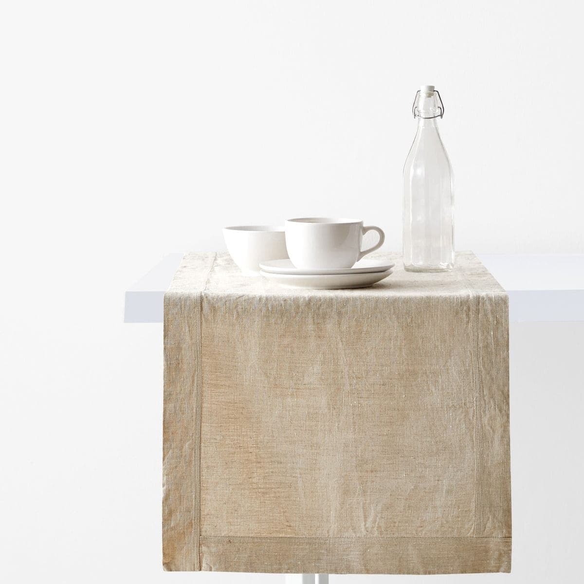 Natural linen table runner styled with white ceramics