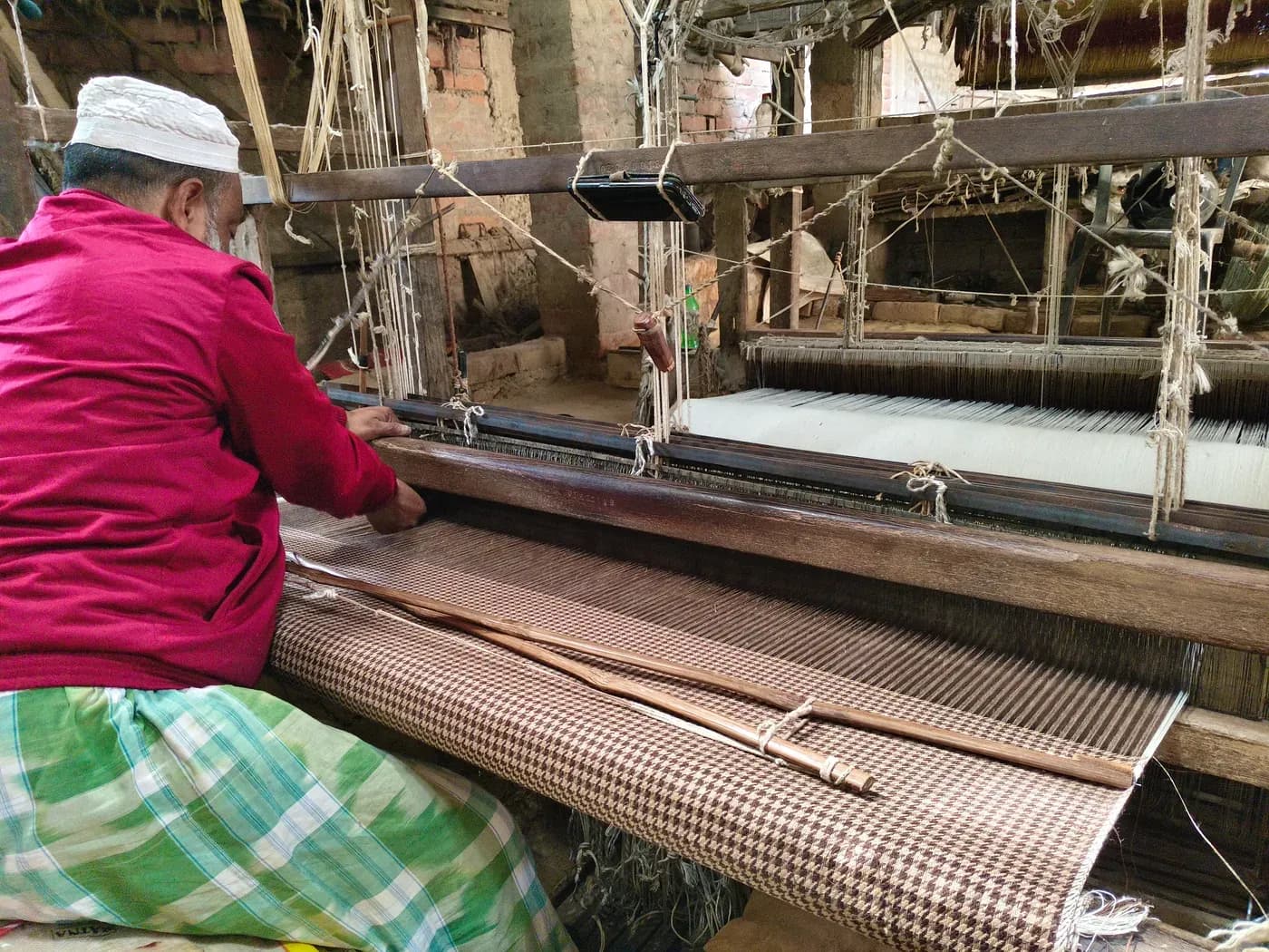 Mubarak weaving checkered fabric on a traditional handloom in Bhagalpur